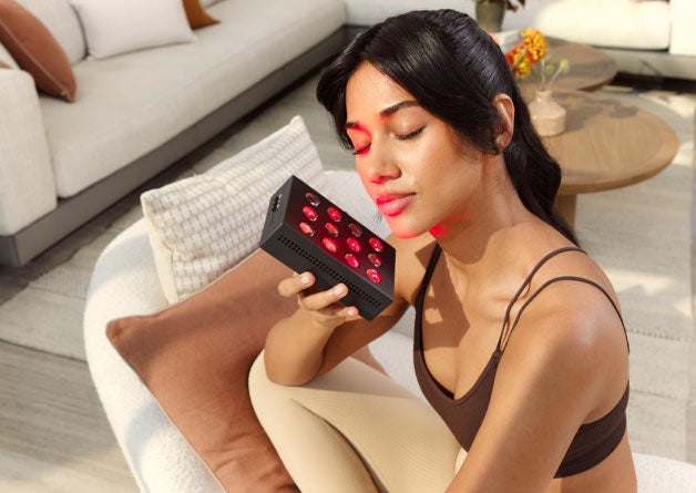 Woman Holding Mini Red Light Device To Face